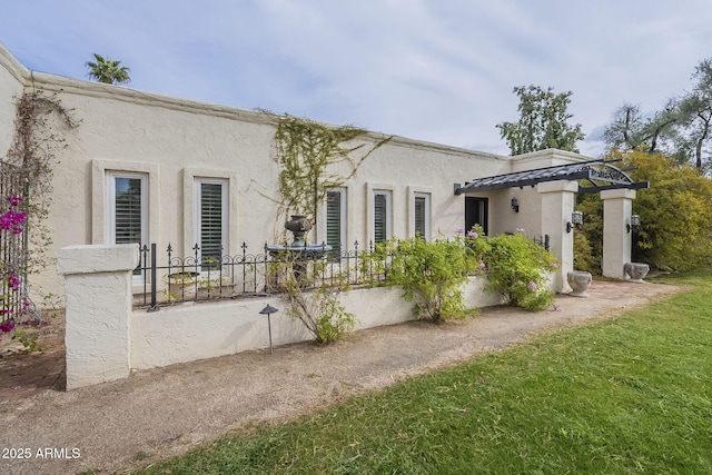 back of house featuring stucco siding, a tiled roof, and fence