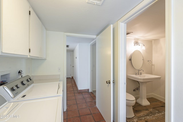 clothes washing area featuring visible vents, baseboards, and washing machine and clothes dryer