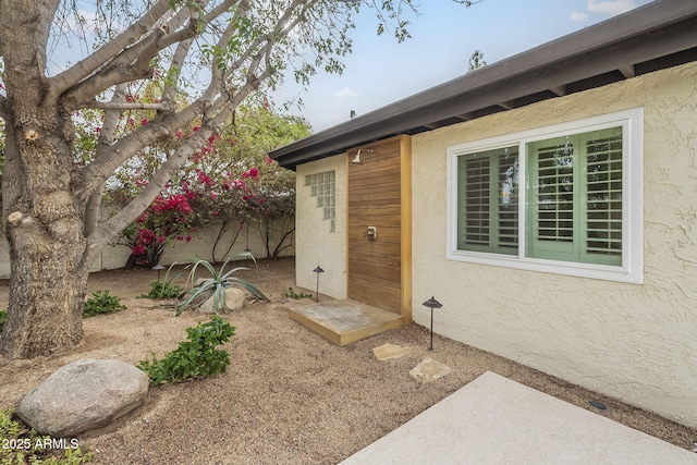 doorway to property featuring stucco siding