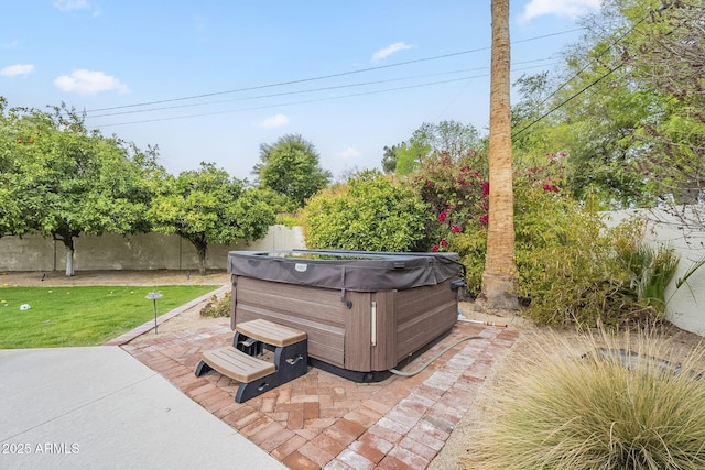 view of patio / terrace with a fenced backyard and a hot tub