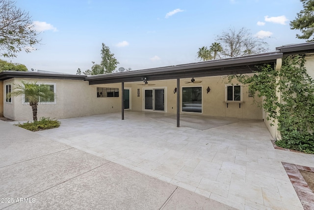 rear view of house featuring a ceiling fan, a patio area, and stucco siding