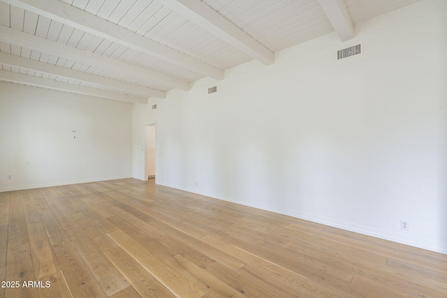 spare room featuring visible vents, beamed ceiling, baseboards, and light wood-style floors