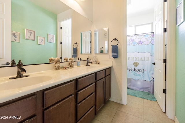 full bathroom featuring double vanity, curtained shower, tile patterned flooring, and a sink