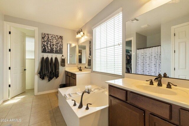 bathroom featuring tile patterned flooring, double vanity, and a bath