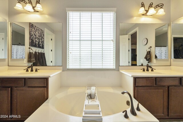 bathroom with dual bowl vanity, a washtub, and a healthy amount of sunlight