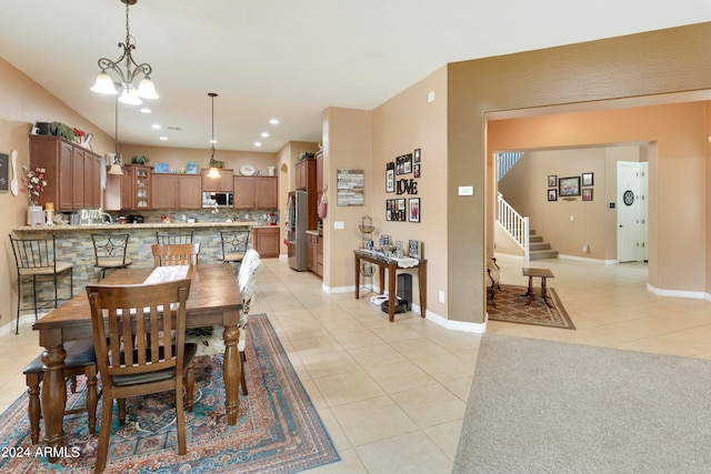 dining room featuring light tile patterned flooring and a notable chandelier