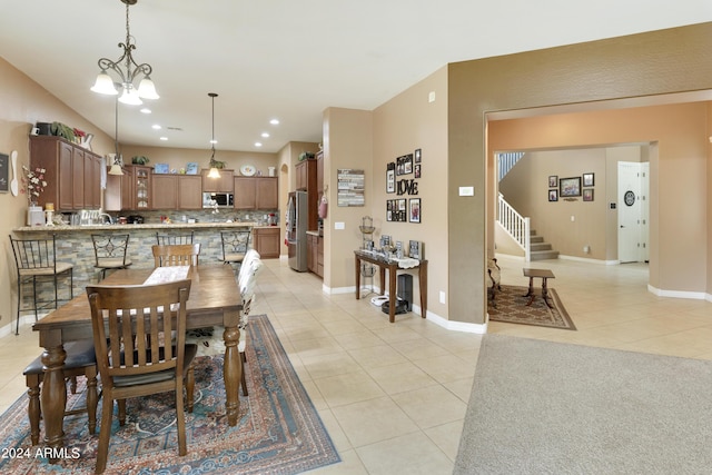 dining room featuring baseboards, stairs, a chandelier, and light tile patterned flooring