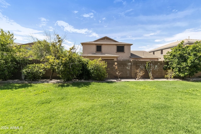 view of front of home with fence, a front lawn, and stucco siding