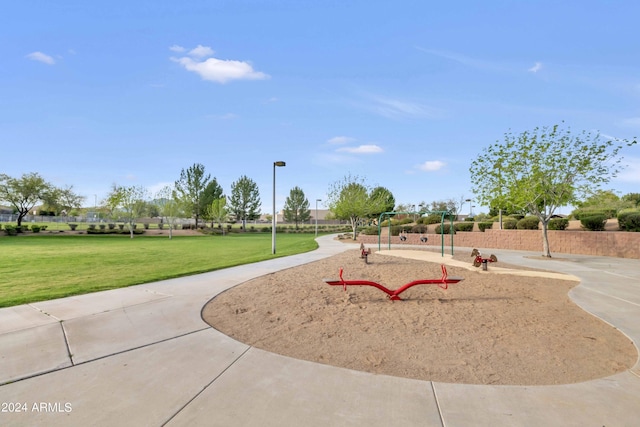 view of home's community with playground community and a lawn