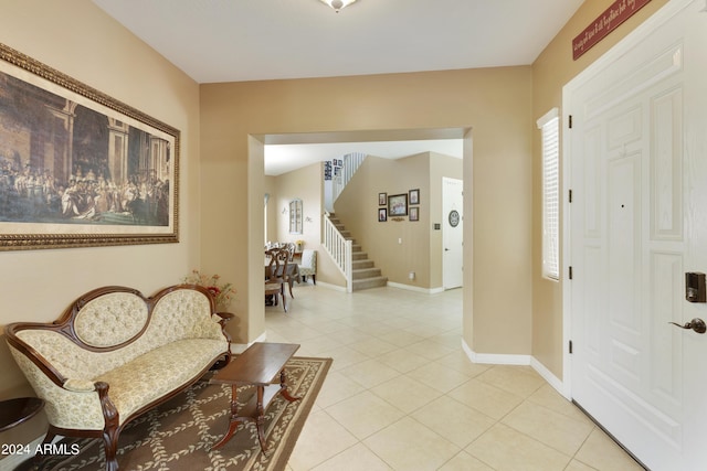 foyer with stairs, light tile patterned floors, and baseboards