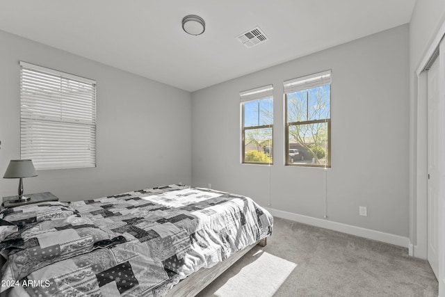 bedroom with light colored carpet and a closet