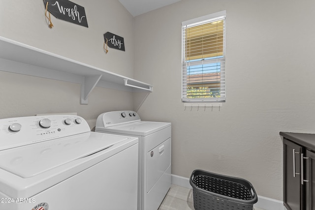 clothes washing area featuring washing machine and dryer and light tile patterned floors