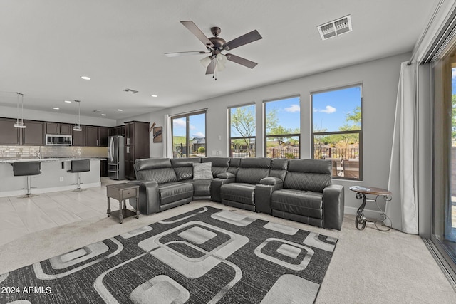 living room with ceiling fan and light colored carpet