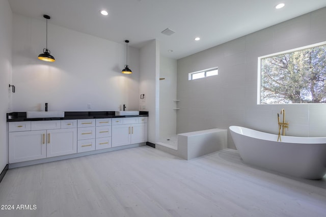 bathroom with hardwood / wood-style flooring, vanity, tile walls, and independent shower and bath