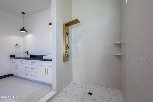 bathroom featuring hardwood / wood-style floors, vanity, and tiled shower