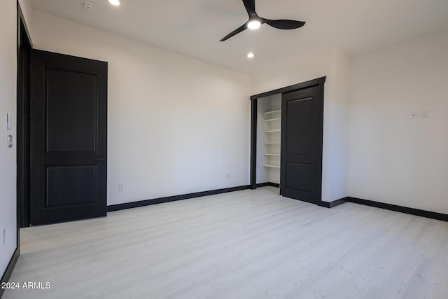 unfurnished bedroom with ceiling fan, a closet, and light hardwood / wood-style floors