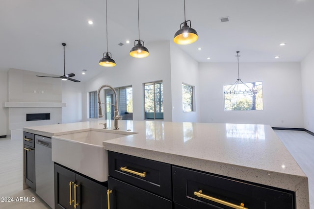 kitchen featuring high vaulted ceiling, ceiling fan with notable chandelier, sink, stainless steel dishwasher, and decorative light fixtures