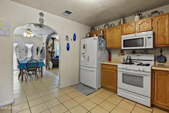 kitchen with white appliances, ceiling fan, a textured ceiling, light tile patterned flooring, and french doors