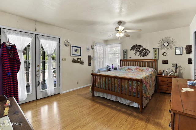 bedroom featuring french doors, access to exterior, multiple windows, and hardwood / wood-style flooring