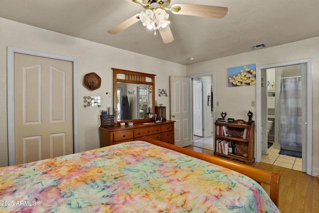 bedroom with ensuite bath, light hardwood / wood-style flooring, and ceiling fan