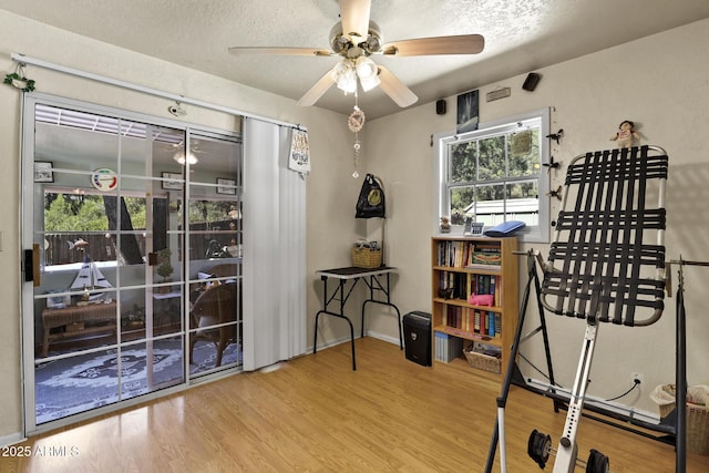 interior space with ceiling fan, light hardwood / wood-style flooring, and a textured ceiling