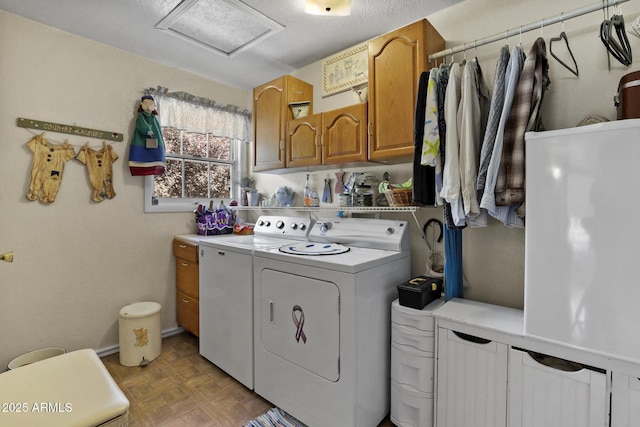 clothes washing area with cabinets, washing machine and dryer, and light parquet flooring