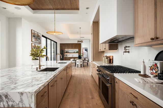 6584 E Gold Dust Ave, Paradise Valley, AZ 85253 - kitchen featuring wall chimney range hood, a tray ceiling, a sink, and stainless steel range