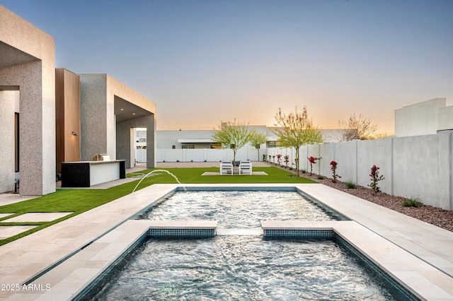 6584 E Gold Dust Ave, Paradise Valley, AZ 85253 - pool at dusk with a fenced backyard, a patio area, a pool with connected hot tub, and a lawn