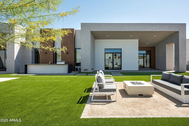 6584 E Gold Dust Ave, Paradise Valley, AZ 85253 - rear view of house with a lawn, an outdoor living space with a fire pit, a patio, and stucco siding