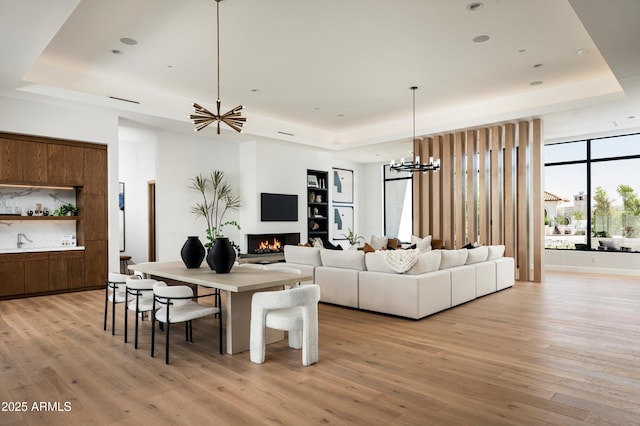 6584 E Gold Dust Ave, Paradise Valley, AZ 85253 - living room with light wood-type flooring, a tray ceiling, and a chandelier