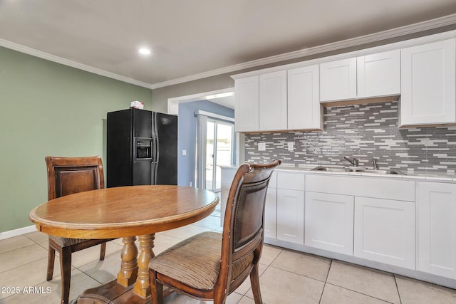 2823 W Banff Ln, Phoenix, AZ 85053 - kitchen featuring black fridge, decorative backsplash, light countertops, and crown molding