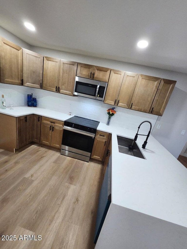 954 E Henry St, Tempe, AZ 85288 - kitchen with stainless steel appliances, light wood finished floors, a sink, light countertops, and recessed lighting