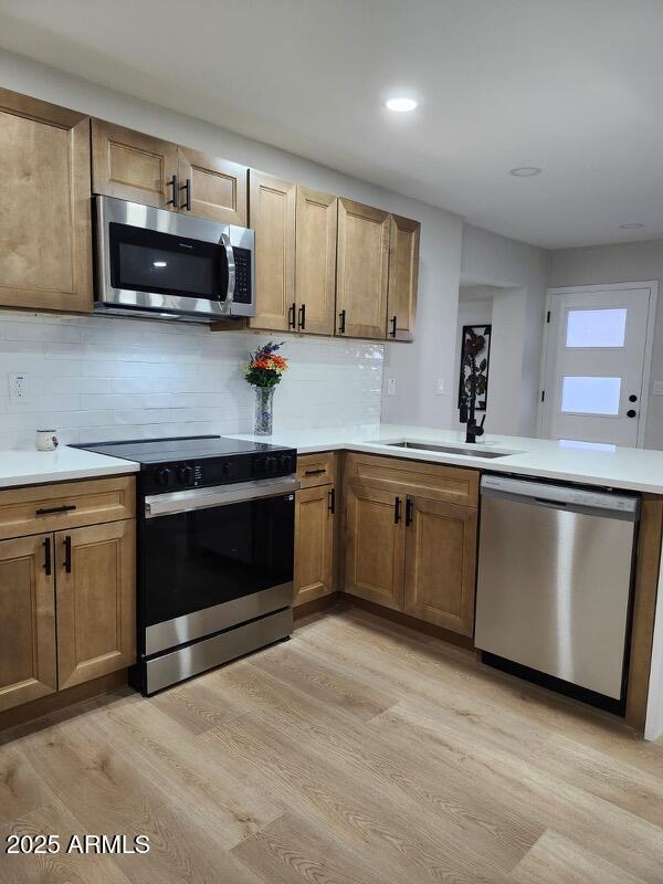 954 E Henry St, Tempe, AZ 85288 - kitchen featuring appliances with stainless steel finishes, light wood-style floors, tasteful backsplash, light countertops, and recessed lighting