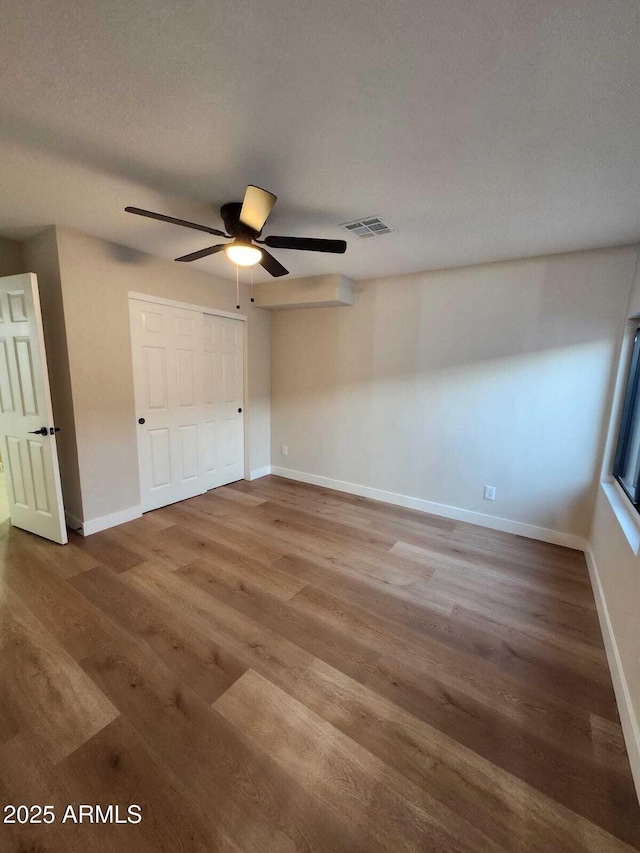 954 E Henry St, Tempe, AZ 85288 - unfurnished bedroom with wood finished floors, baseboards, a ceiling fan, and a closet