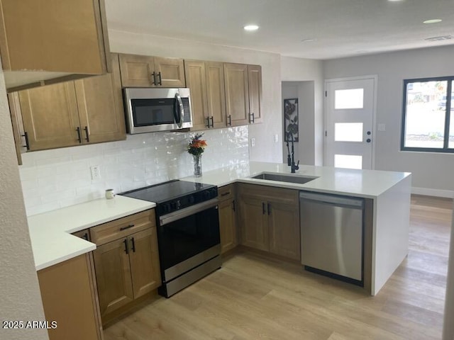 954 E Henry St, Tempe, AZ 85288 - kitchen featuring stainless steel appliances, a peninsula, tasteful backsplash, light wood finished floors, and recessed lighting