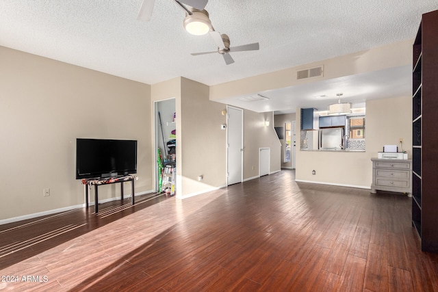 living room with ceiling fan, a textured ceiling, and dark hardwood / wood-style flooring