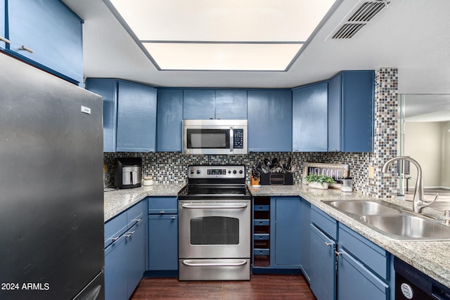 kitchen with blue cabinets, appliances with stainless steel finishes, sink, and decorative backsplash