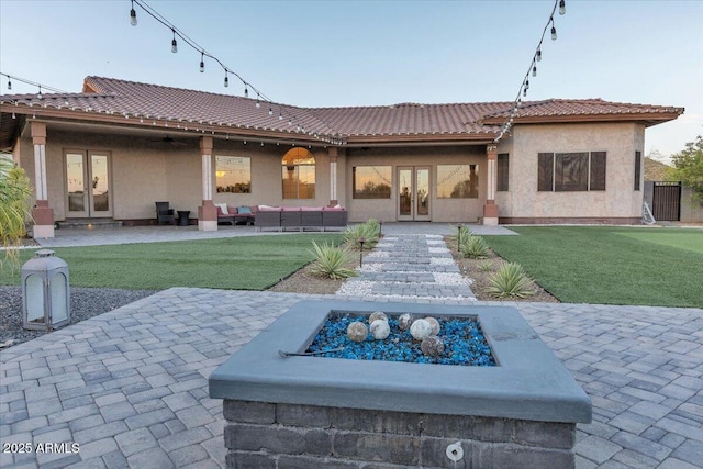 9183 W Shamel Ash Rd, Peoria, AZ 85383 - back of property with french doors, a patio, a lawn, and an outdoor living space with a fire pit