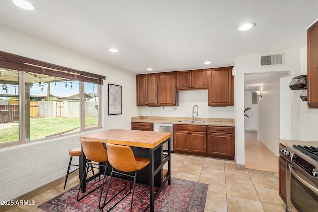 844 E Ruth Ave, Phoenix, AZ 85020 - kitchen with a sink, stainless steel appliances, recessed lighting, light tile patterned flooring, and brown cabinets