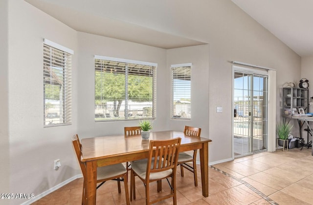 dining area with lofted ceiling, light tile patterned flooring, and baseboards