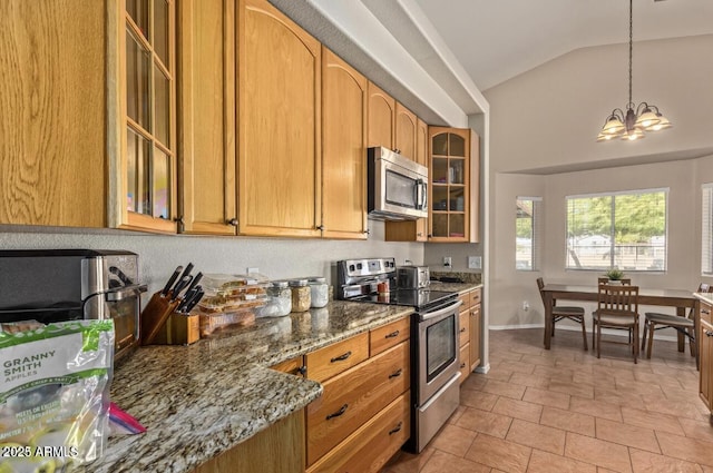 kitchen with glass insert cabinets, vaulted ceiling, stainless steel appliances, stone counters, and a notable chandelier