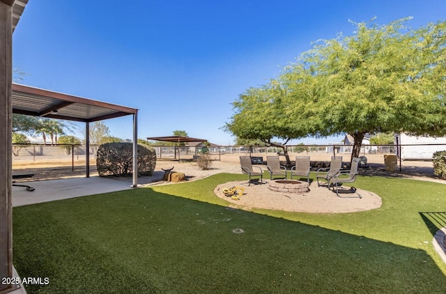 view of yard featuring a fire pit, a patio, and fence