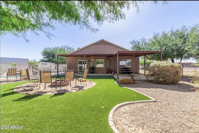 back of house with a patio, a lawn, fence, and stucco siding