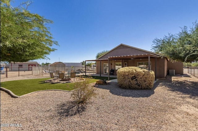 rear view of property featuring a yard, a fenced backyard, a patio, and stucco siding