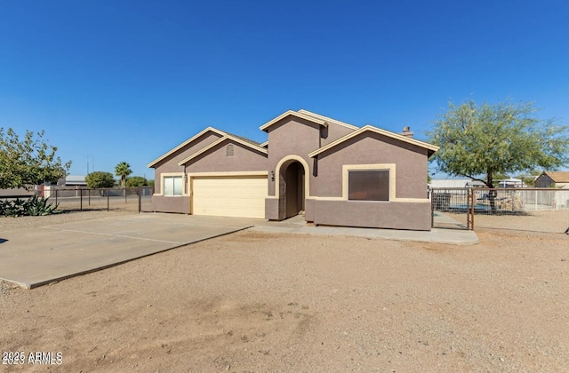 view of front facade with concrete driveway, fence, an attached garage, and stucco siding