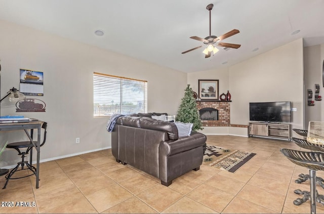 living area featuring lofted ceiling, ceiling fan, light tile patterned flooring, baseboards, and a brick fireplace