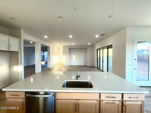 kitchen featuring stainless steel dishwasher, sink, a kitchen island with sink, and light brown cabinets