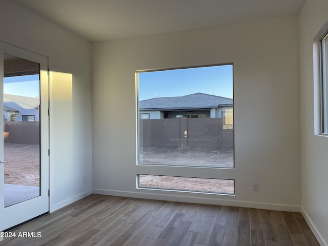 unfurnished room featuring a healthy amount of sunlight and hardwood / wood-style floors