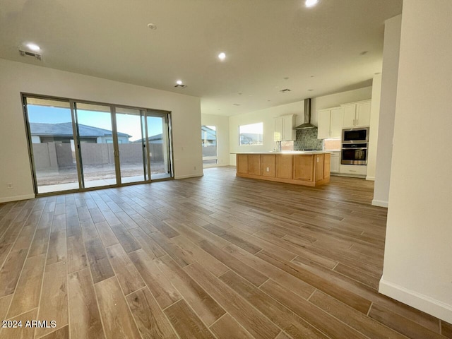 unfurnished living room with sink and light hardwood / wood-style flooring