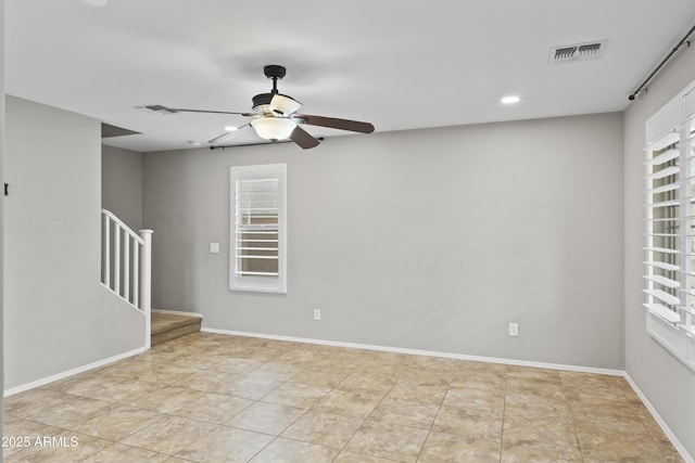 tiled spare room featuring ceiling fan